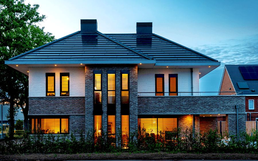 Een woning met zonnepanelen in de avond, van Solinso.